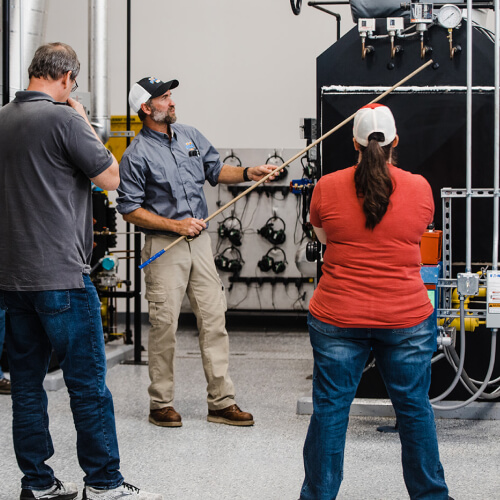 Instructor gesturing at a boiler