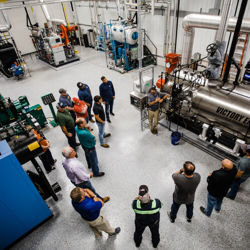 Students gathered in a semicircle around a boiler